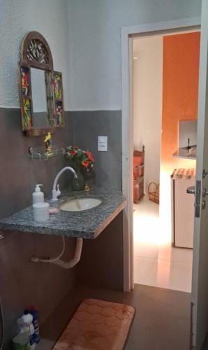 a bathroom with a sink and a counter with a mirror at Estância Jockey Clube in Sao Jose do Rio Preto