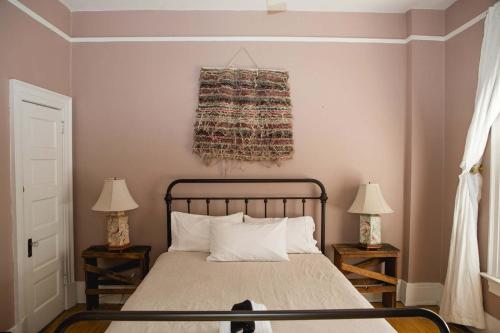 a bedroom with a bed with two lamps and a rug on the wall at Object Hotel 2BR Room 2G in Bisbee