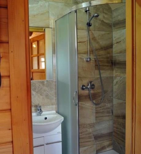a bathroom with a shower and a sink at Domki PIĘKNY WIDOK górne - Solina Centrum in Solina