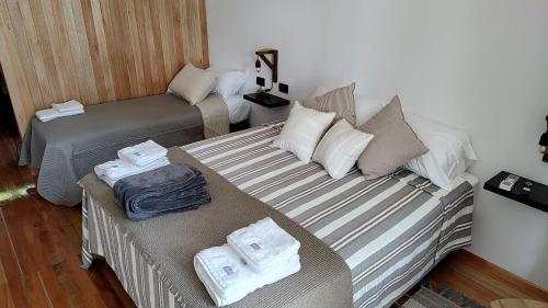 a room with two beds and a couch with towels at Refugios de Rio Ilo in Concepción del Uruguay