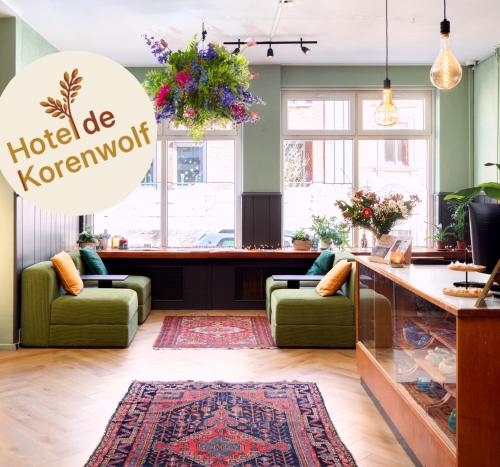 a hotel korenatown lobby with green chairs and a counter at Hotel de Korenwolf in Gulpen