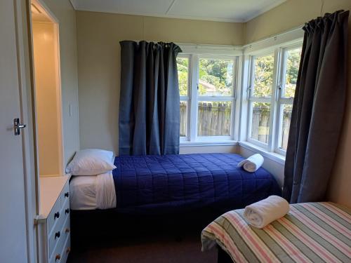 a bedroom with two beds and a window at Waitangi Beach Unit B in Paihia