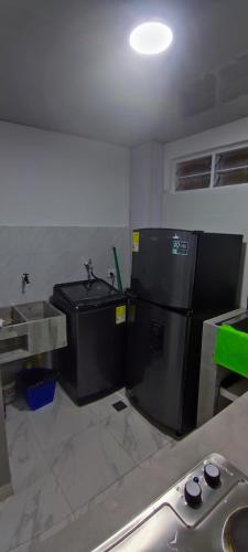 a kitchen with a black refrigerator and a sink at Relax in El Cerrito
