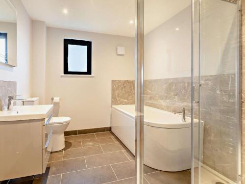 a bathroom with a tub and a toilet and a sink at 2 Bed in Somerton oc-92126 in Babcary