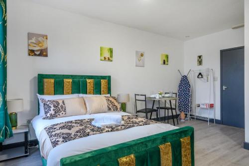 a bedroom with a large bed with a green headboard at 78F3 - Cosy & Welcoming studio in Bradford