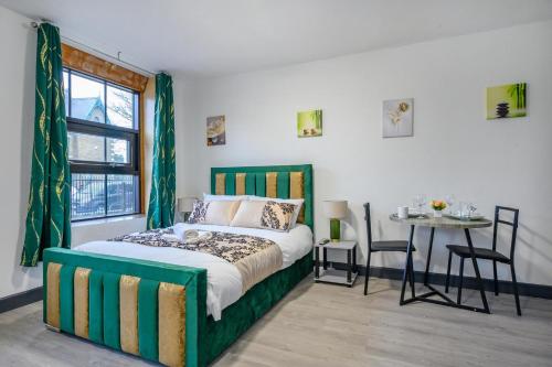 a bedroom with a bed and a table and a window at 78F3 - Cosy & Welcoming studio in Bradford