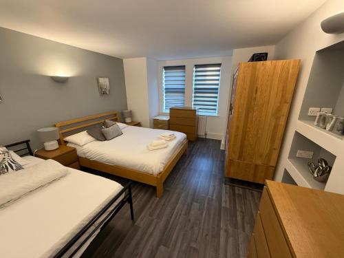 a small room with two beds and a window at Bournemouth Hot Tub & Sauna Holiday Let in Bournemouth