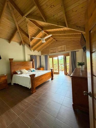 a bedroom with a bed and a wooden ceiling at Villa Ana Rosa in Jarabacoa