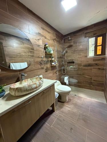 a bathroom with a sink and a toilet and a shower at Villa Ana Rosa in Jarabacoa