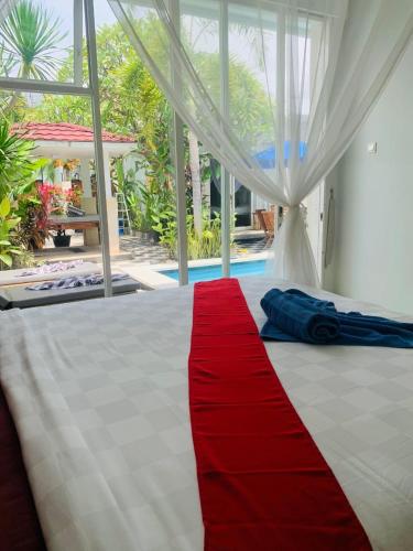 a red blanket on a bed with a red stripe at Villa WENHOMANN in Lovina