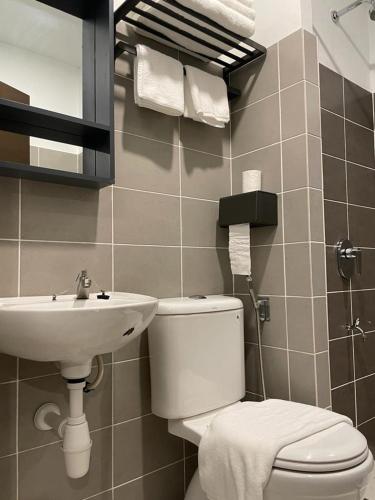 a bathroom with a toilet and a sink at Soho Tabuan Kuching in Kuching