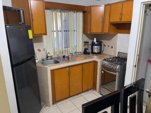 a small kitchen with a sink and a refrigerator at casa renta vacacional en mazatlan in Mazatlán