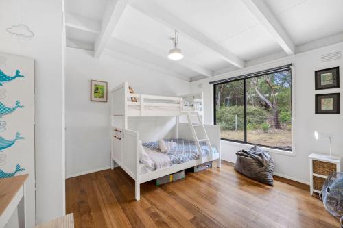 a white room with a bunk bed and a window at Oceanside Escape in Aireys Inlet