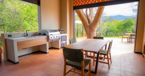 a kitchen with a table and a sink and a table and chairs at BEE Suites Santa Ana - San Jose in San José