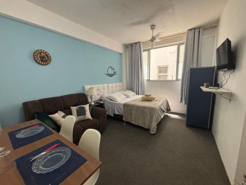 a living room with a couch and a bed at Apes Raizes Douradas in Campinas