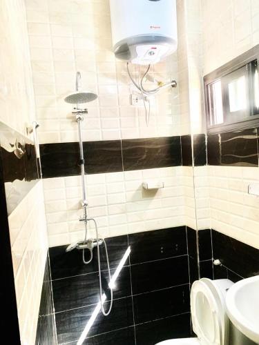 a bathroom with a shower and a toilet and a sink at Kantora Red almadie in Dakar