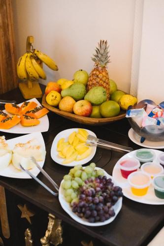 a table topped with plates of fruit on a table at Teatro Hotel Boutique in Ouro Preto