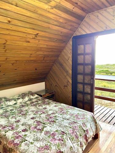 a bedroom with a bed and a wooden ceiling at Chalé Horizonte do Silva in Arroio do Silva