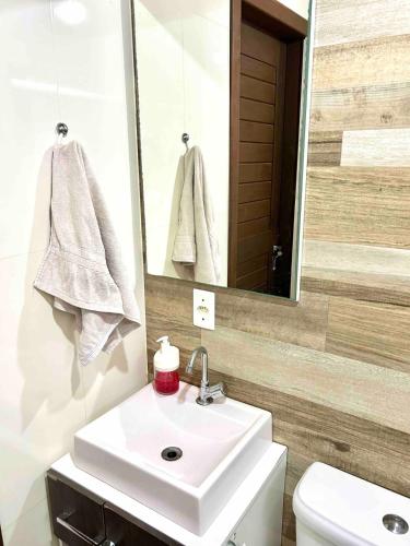 a bathroom with a sink and a mirror and a toilet at Chalé Horizonte do Silva in Arroio do Silva