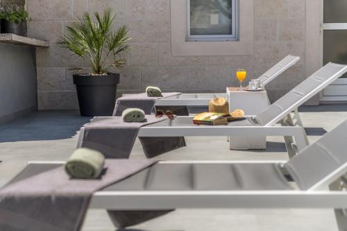 a patio with two tables and chairs with food on them at Authentic Dalmatian stone villa in Selca