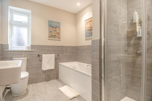 a bathroom with a tub and a toilet and a sink at 4 Bed in Aldeburgh oc-16faw in Aldeburgh