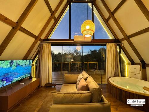 a living room with a tub and a large window at Chalés Exclusivos com Jacuzzi em Bonito Mato Grosso do Sul in Bonito