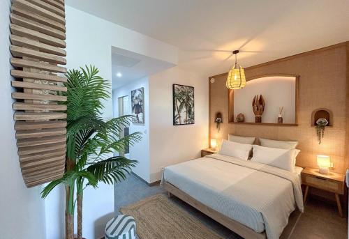 a bedroom with a bed and a plant in it at Palm Beach Studio - New Beach Residence in Saint Martin