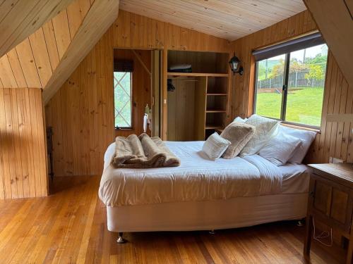 a bedroom with a large bed in a attic at Cygnet Cabin in Lymington