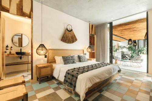 een slaapkamer met een groot bed en een balkon bij NAJ Tulum in Tulum