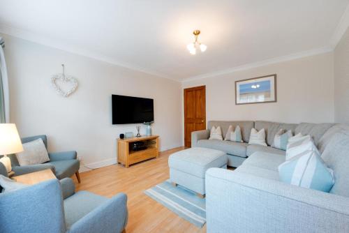 a living room with two couches and a flat screen tv at 4 Bed in Southwold oc-ivy in Southwold