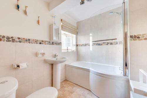 a bathroom with a tub and a sink and a toilet at 4 Bed in Southwold oc-ivy in Southwold