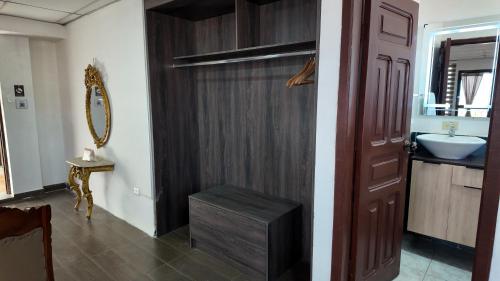 ein Badezimmer mit einer Holztür und einem Waschbecken in der Unterkunft Hotel Royalty in Riobamba