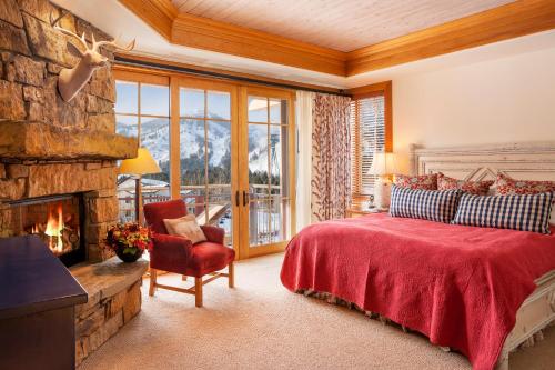 a bedroom with a fireplace and a bed with a red blanket at Faraway Jackson Hole in Teton Village