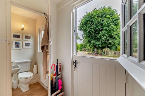 a bathroom with a toilet and a window at 3 Bed in Snape oc-g29478 in Snape