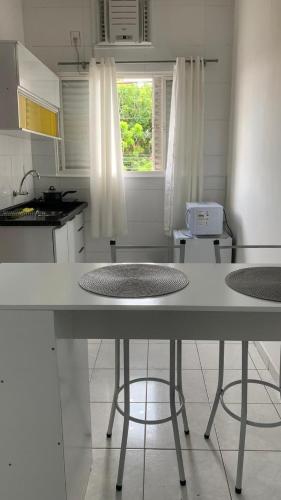 a white kitchen with a table and a window at Kitnet Equipada in Sao Jose do Rio Preto