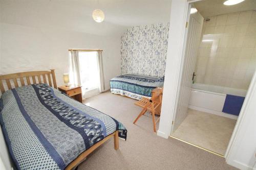 a bedroom with two beds and a bath tub at 3 Bed in Swansea oc-hh405 in Llanmadoc