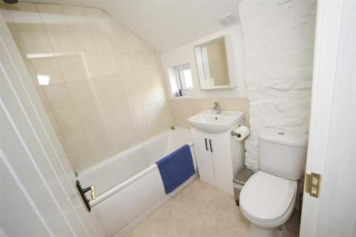 a bathroom with a toilet and a sink and a tub at 3 Bed in Swansea oc-hh405 in Llanmadoc