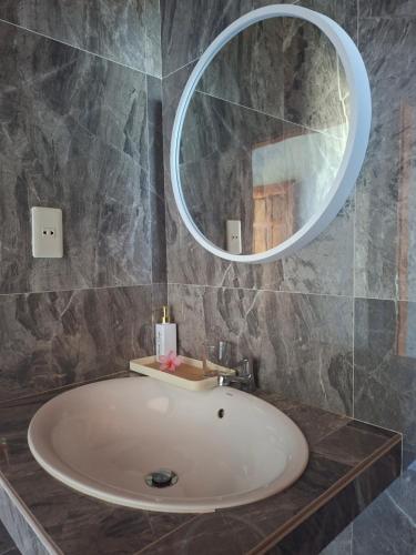 a bathroom with a sink and a mirror at Juma cottages in Tuktuk Siadong