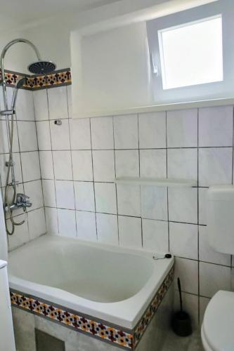 a bathroom with a tub and a toilet and a window at Apartments with parking space Vodice - 927 in Vodice