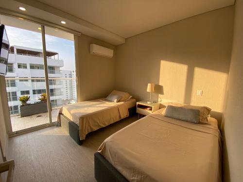 a hotel room with two beds and a large window at Luxury Ocean View Aparment in Cartagena de Indias