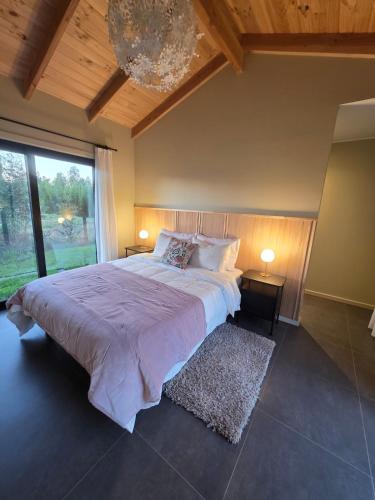 a bedroom with a large bed and a large window at Estancia del Sol in Putúe