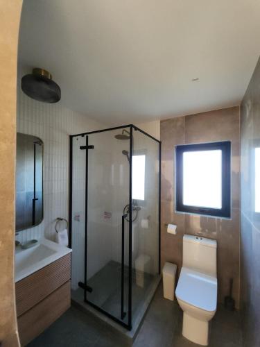 a bathroom with a shower and a toilet and a sink at Estancia del Sol in Putúe