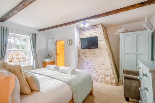 a bedroom with a bed and a tv on a wall at 3 Bed in Thornham oc-983 in Thornham