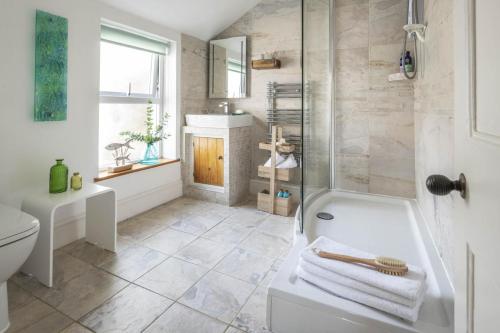 a bathroom with a shower and a tub and a toilet at 3 Bed in Porthleven oc-12bayv in Porthleven