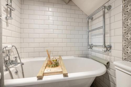a bathroom with a white tub with a wooden tray on it at 2 Bed in Scarborough oc-sa003 in Ravenscar