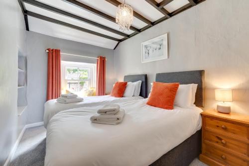 two beds in a bedroom with orange pillows at 2 Bed in Thwaite oc-ds946 in Thwaite