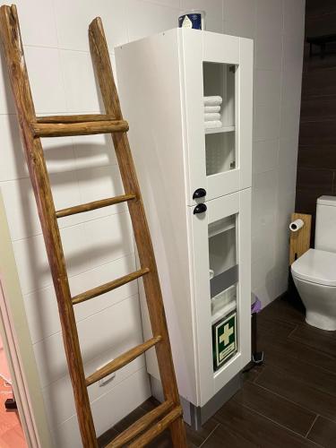 a ladder in a bathroom with a white refrigerator at Casa das Andorinhas - AL in Castelo de Vide