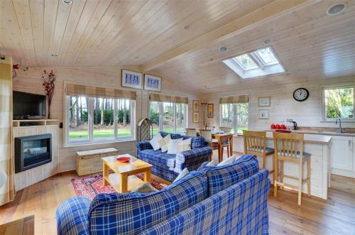 a living room with blue couches and a kitchen at 2 Bed in Weybourne oc-1628 in Kelling