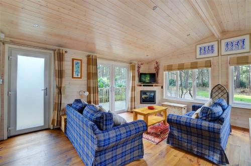 a living room with two blue chairs and a table at 2 Bed in Weybourne oc-1628 in Kelling