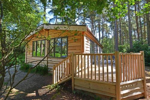a wooden cabin in the woods with a wooden fence at 2 Bed in Weybourne oc-1628 in Kelling